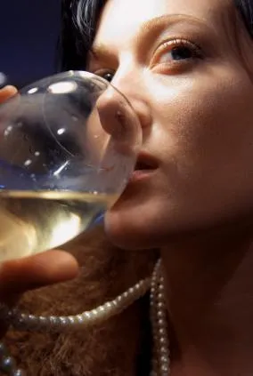 Woman drinking a glass of white wine close up